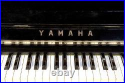 A 1961, Yamaha U2 upright piano with a black case and brass fittings