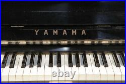 A 1962, Yamaha U2 upright piano with a black case and brass fittings