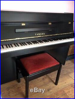A 1986, Yamaha LU 101 upright piano with a black case