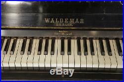 A Waldemar upright piano with a black case, inlaid with doves in a maple tree