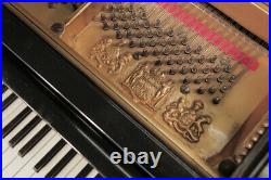 An 1896, Schiedmayer grand piano with a black case, filigree music desk and turn
