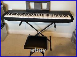 Yamaha P-45B digital piano with stand, stool, foot pedal, carry case, and books